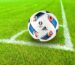 A ball pump with needle beside a soccer ball
